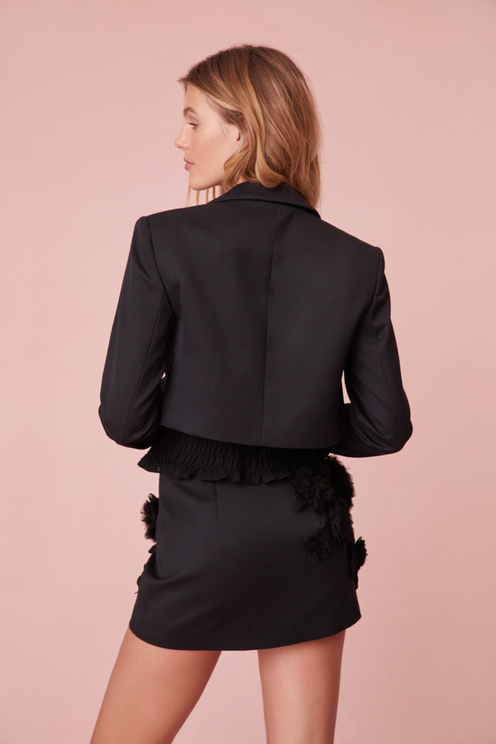Black mini skirt with top-applied handmade rosettes.