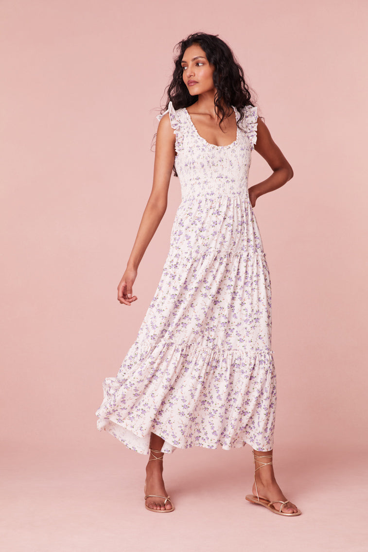Midi dress with ruffle sleeves at the shoulders that merge around the scoop neck. The fitted smocked bodice releases into a midi skirt decorated with custom lace insets.