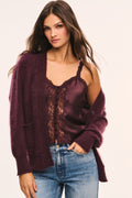 Merlot cardigan worn open with V-neck and long sleeves, button front and patch pockets