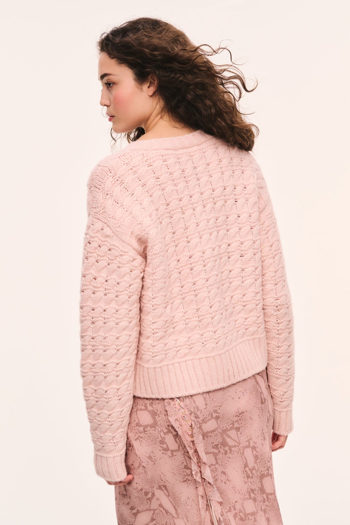Back view of pink textured knit pullover with ribbed cuffs