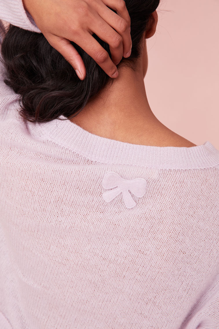 Cashmere cardigan featuring ribbed detailing with loops along the seams. Finished with our custom bow buttons down center front and a bow embroidery on the back.