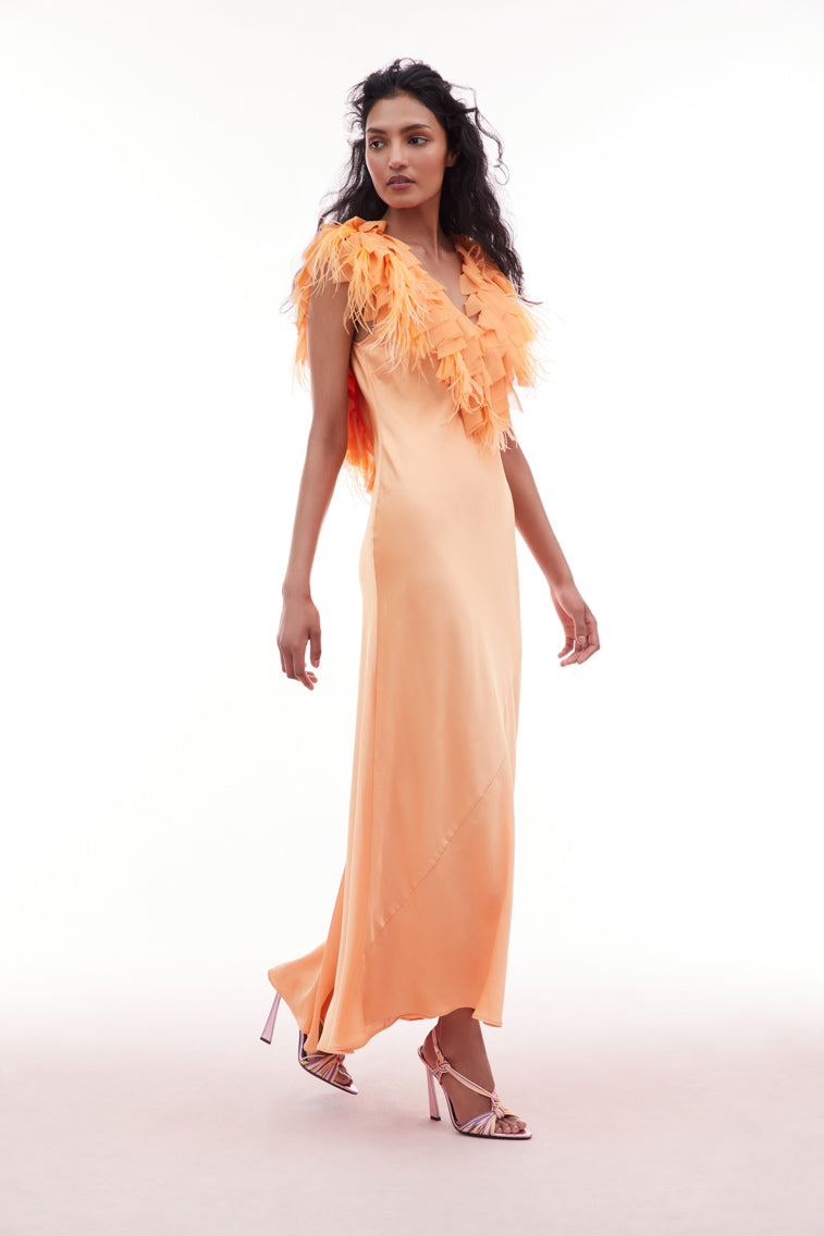 Orange gown with a deep v-neckline and form-fitting skirt featuring an open back adorned with chiffon tatters and ruffles mixed in with accent feathers.