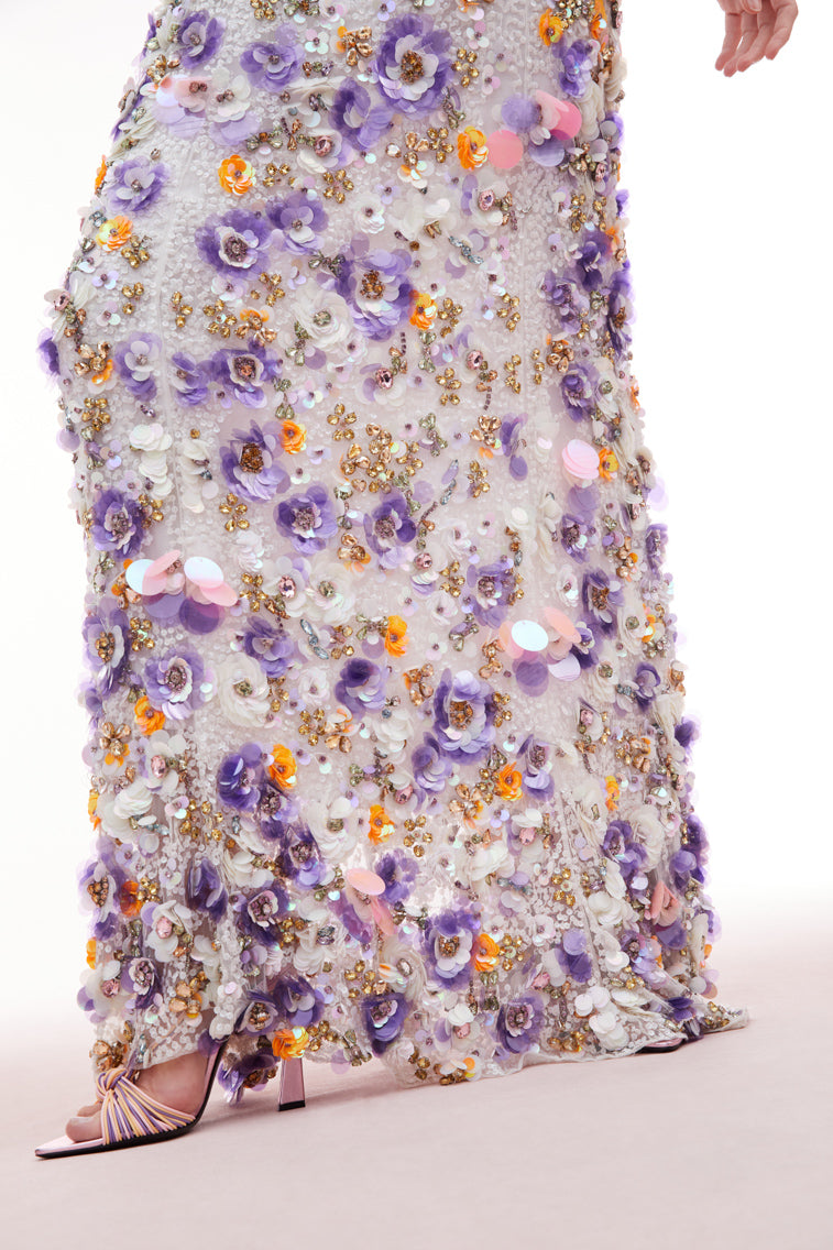 Maxi dress with sequin embroidered mesh on top, lilac and tangerine payettes with sequins, rhinestones, and crystals sprinkled throughout. The piece begins with a deep v-neckline and delicate spaghetti straps before falling to the bodice which features an internal corset with a shelf bra.