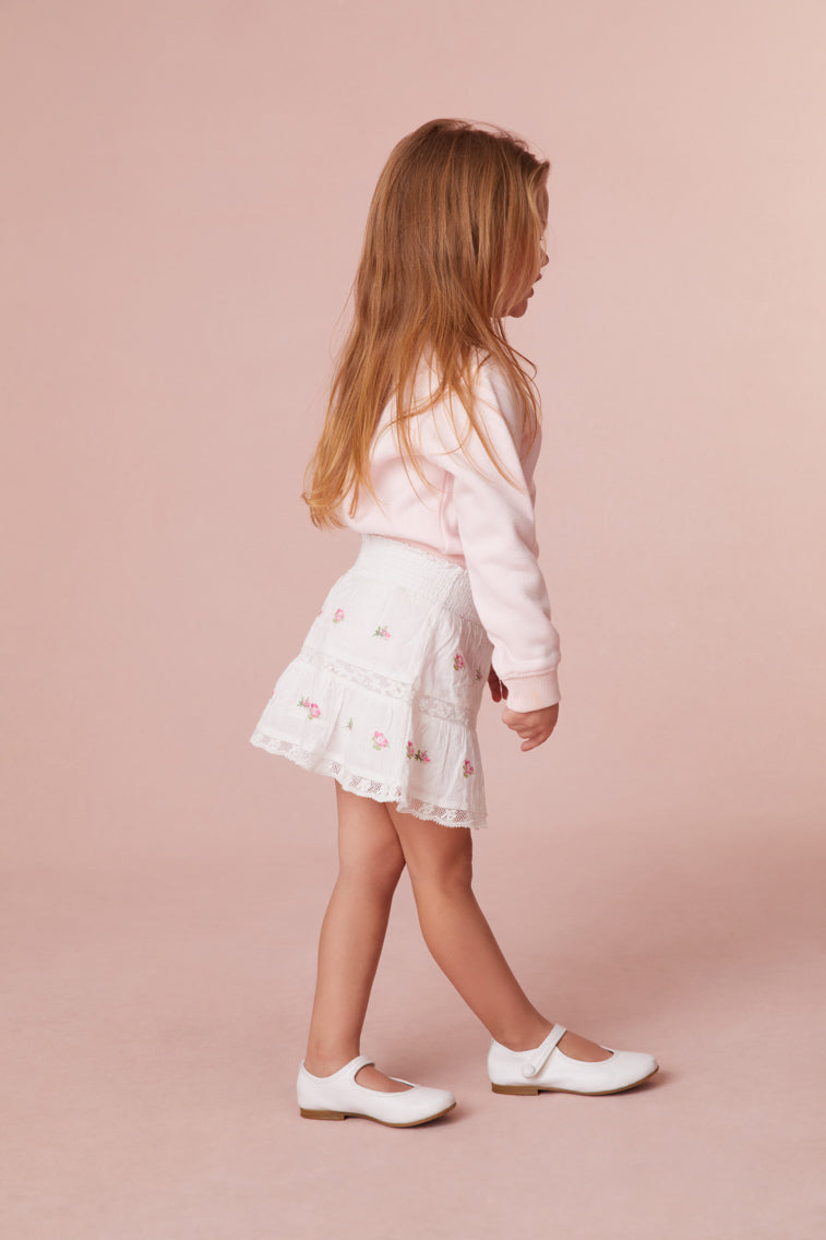 Girls skirt embroidered with small rosebuds all over, an elasticated waistband and lace details all over.