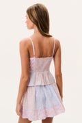 Woman wearing a pastel striped dress with a white background