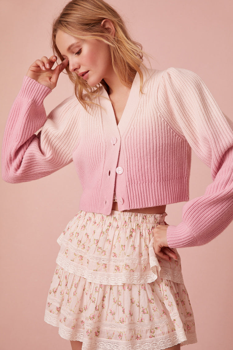 The dip-dye technique gives off a stunning gradient effect where it’s darker on the bottom and lighter on the top. This cropped sweater, has a v-neck that descends to four flower buttons.