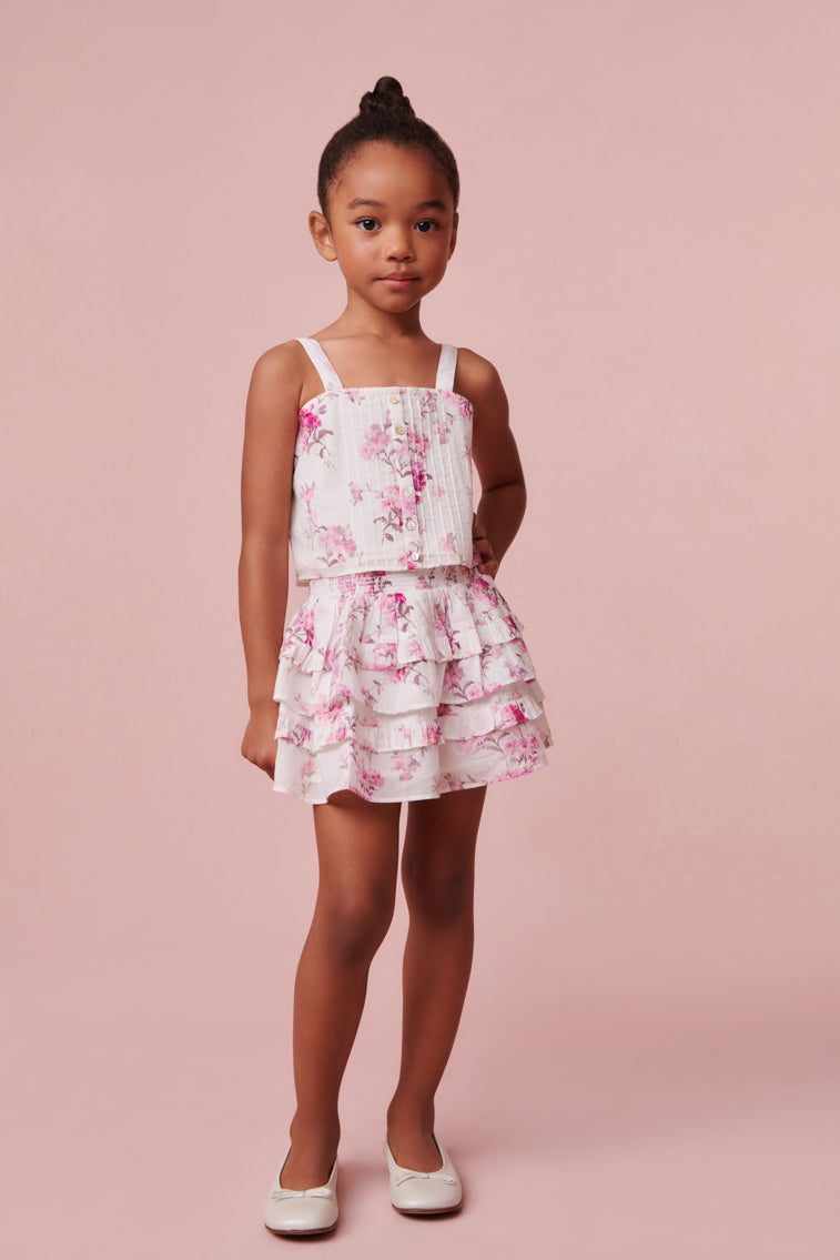 Mini skirt with a wide smocked waistband and two shirred tiers with ruffle details.