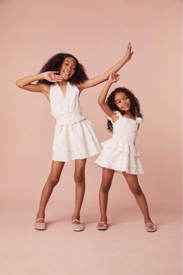Girls mini dress with raw-edge details outlining the v-neckline, a smocked bodice, and an airy skirt with raw-edge trim for a playful touch.