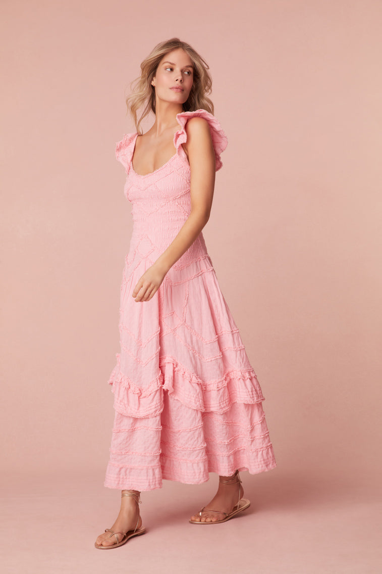 Midi dress featuring a smocked bodice throughout that releases at the high hip into a skirt. Includes top-applied ruffle details at the bodice in a chevron design, and intricate ruffle details at the skirt.