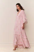 Woman wearing a pink floral dress against a white background