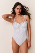 Woman wearing Striped floral swimsuit against a beige background