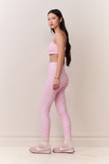 Woman wearing a pink athletic outfit on a plain background