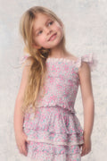 Young girl wearing a floral dress against a light background