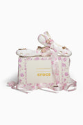 Floral-patterned Crocs shoes with a matching box on a white background