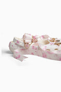 Rubber shoe with pink floral design and gold charm on a white background