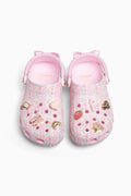 Pink rubber clogs with decorative charms on a white background