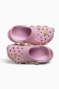 Pink children's shoes with decorative elements on a white background