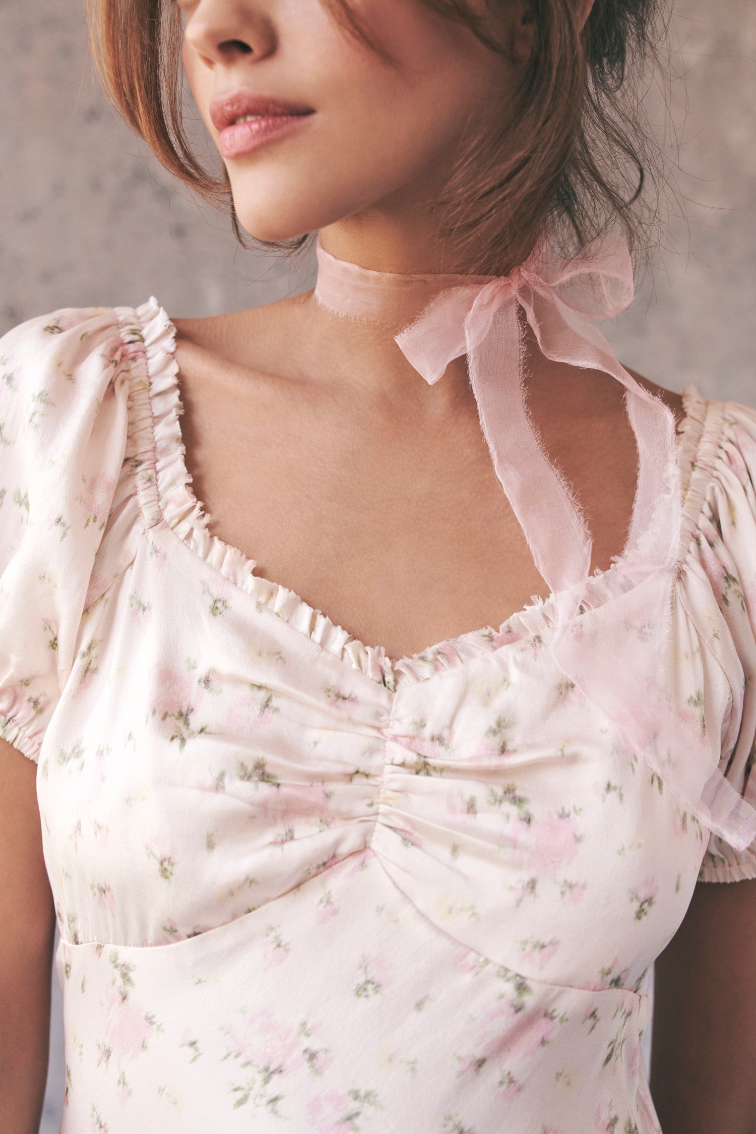 Close up image detailing neckline and floral print on cream maxi dress