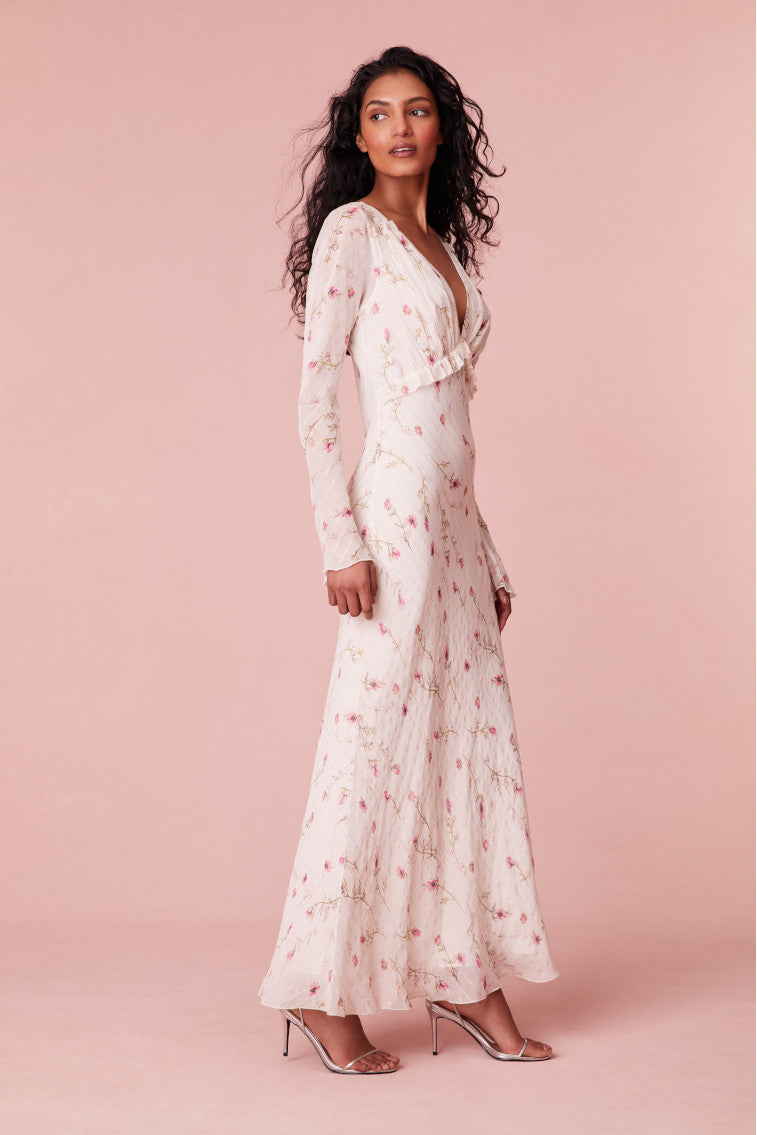 Floral maxi dress with fitted long bell sleeves, a ruched bodice, and stripes running throughout with ruffles on the waist.