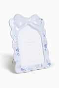 Decorative white bow-shaped object with floral patterns on a white background