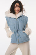 Woman wearing a blue denim vest with white fur trim on a white background