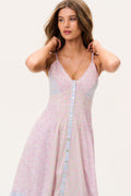 Woman wearing a light pink and blue dress sleeveless long dress on a white background