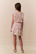 Girl wearing a floral ruffle dress against a plain background