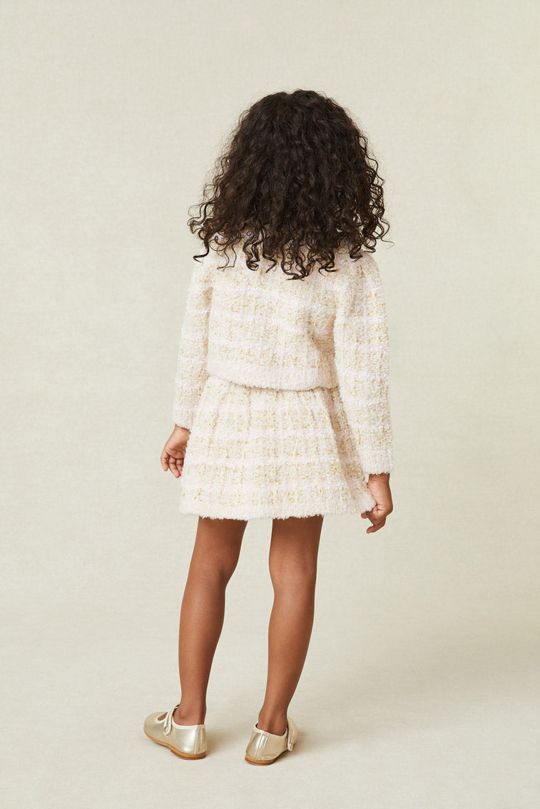 Back image of model wearing girl's cream tweed cardigan with buttons up front