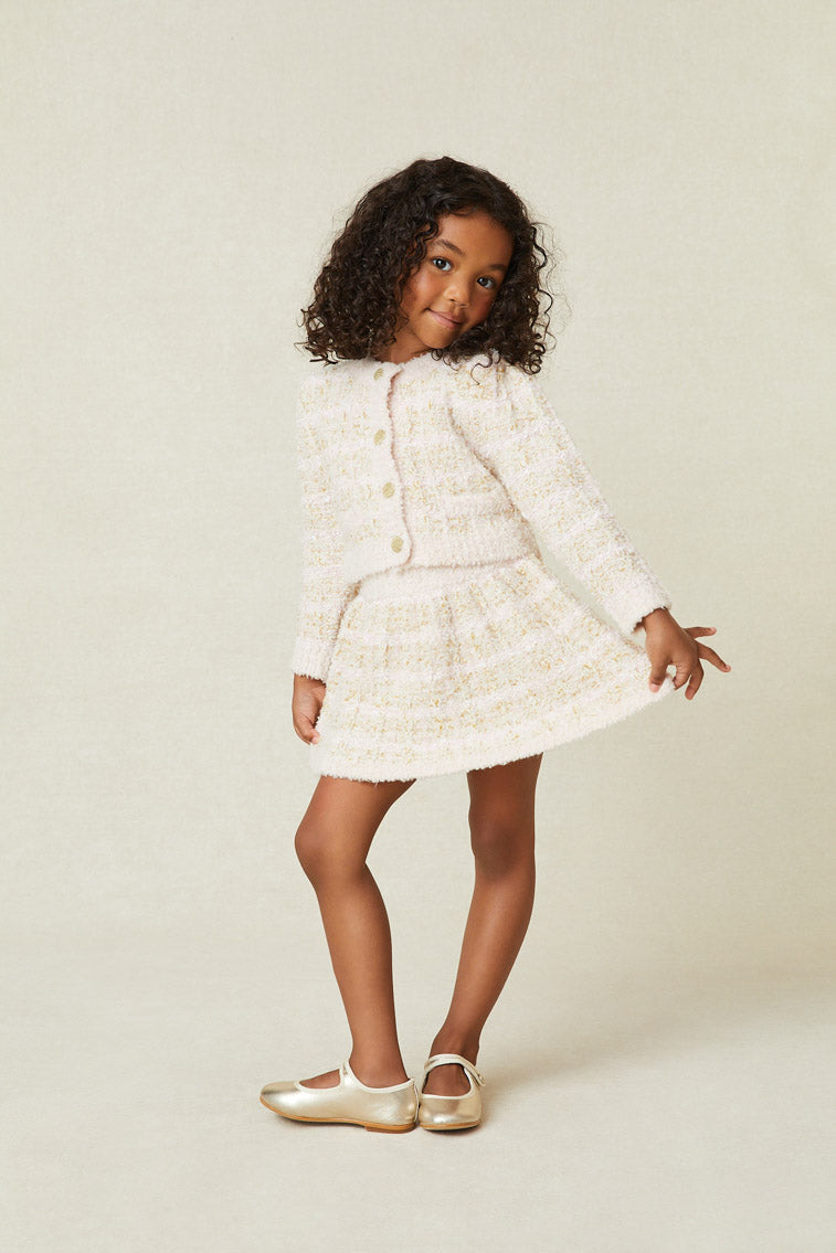 Model wearing girl's cream striped mini skirt. 