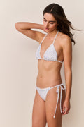 Woman wearing striped floral bikini set thin straps on a beige background