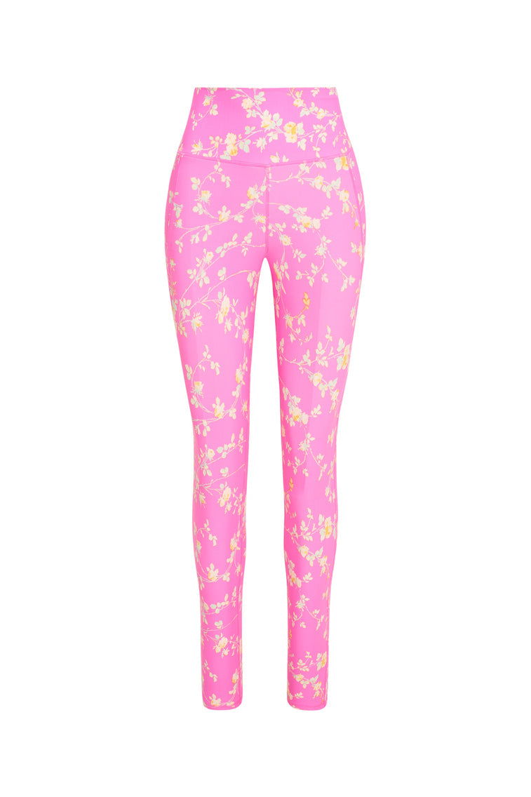 Pink high-waisted leggings featuring a yellow floral print with a sleek style and feature a smocked waistband for a seamless performance. 