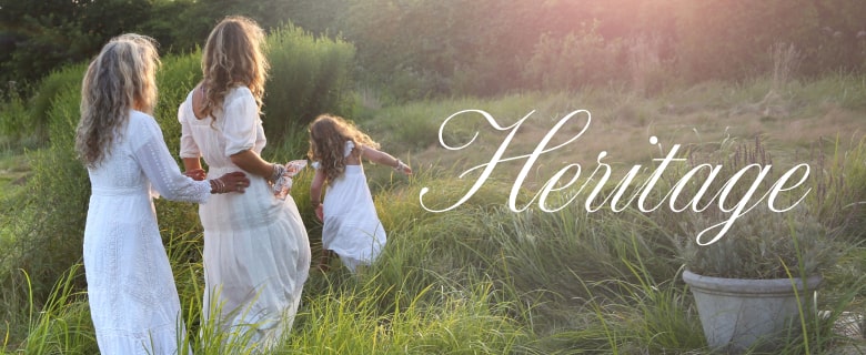 The LoveShackFancy founder walking in a field with her daughters, all wearing white dresses from the Heritage Collection