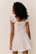 Girl wearing Light pink ruffle sleeve top with floral pattern and matching skirt