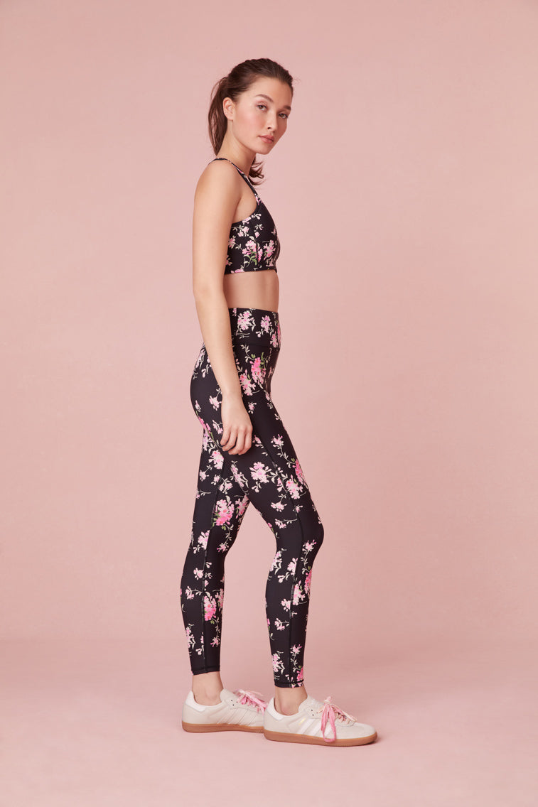 Black featuring pink floral print high-waisted leggings with a sleek style and feature a smocked waistband for a seamless performance.
