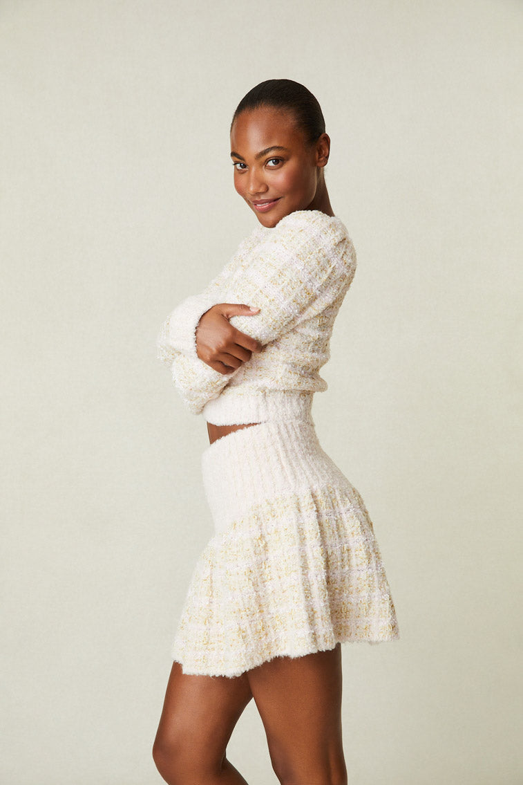 Side image of model wearing cream tweed mini skirt