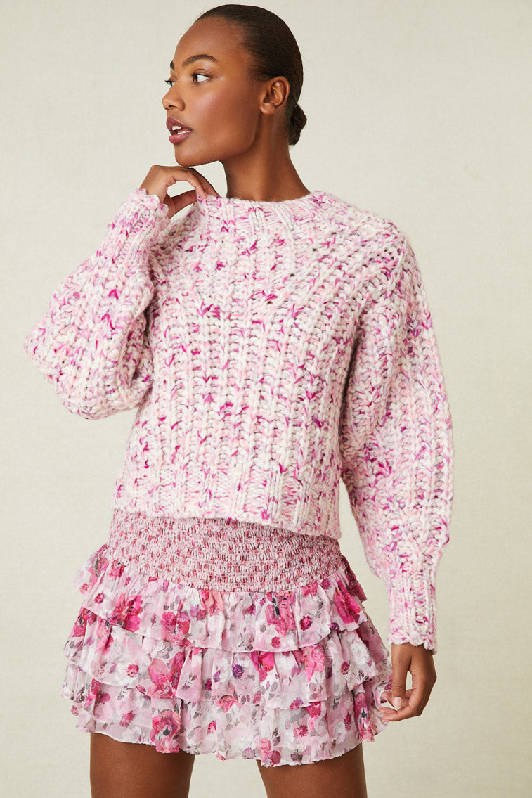 Model wearing multi-tone pink knit sweater. Has a subtle balloon sleeve.