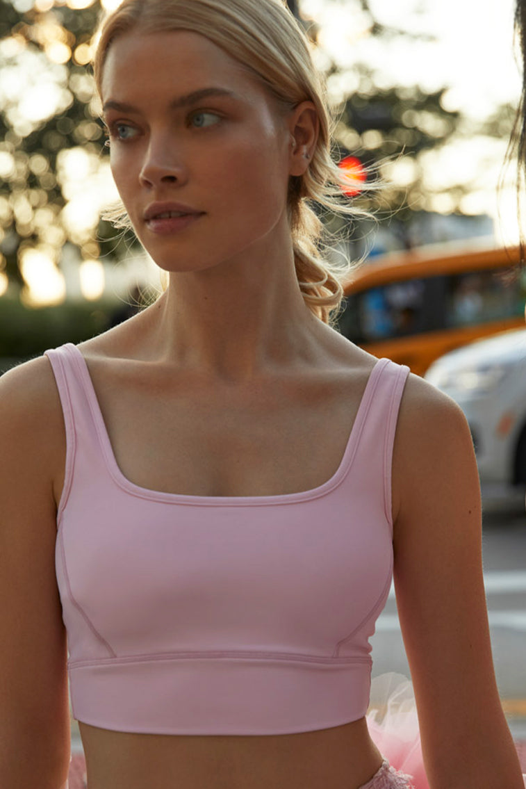 Pale pink lightweight sports bra top has a cropped hem