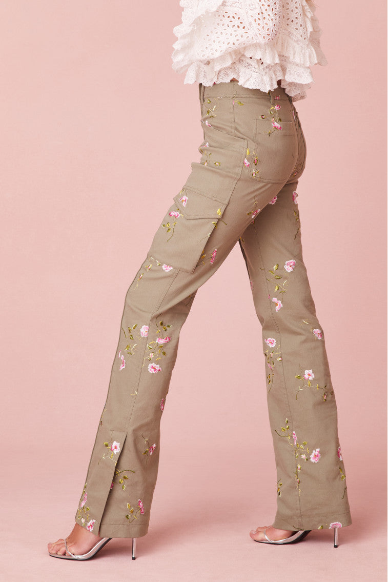 Olive green slim fit and full length pants with pink flowers embroidered all over. Includes a slit detail on the sides and cargo pockets.