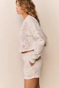 White eyelet accented pullover against a white background