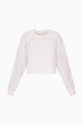White eyelet accented pullover against a white background