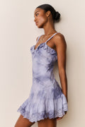 Woman wearing a Blue and white tie-dye lace dress against a plain background