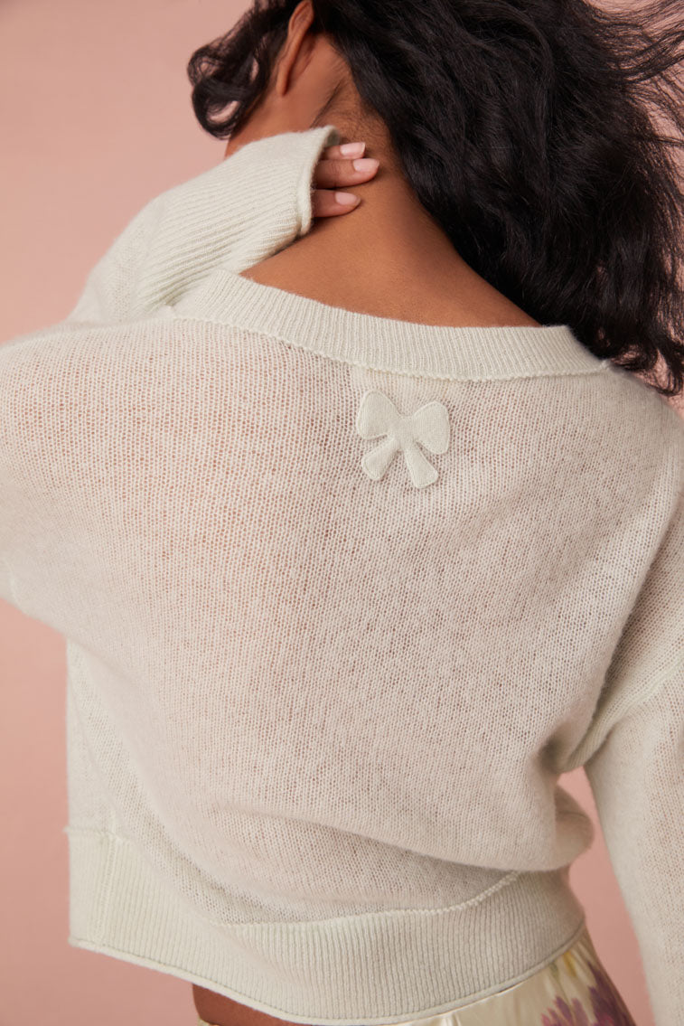 Cashmere cardigan featuring ribbed detailing with loops along the seams. Finished with our custom bow buttons down center front and a bow embroidery on the back.