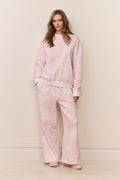 Woman wearing a pink printed pajama set against a plain background