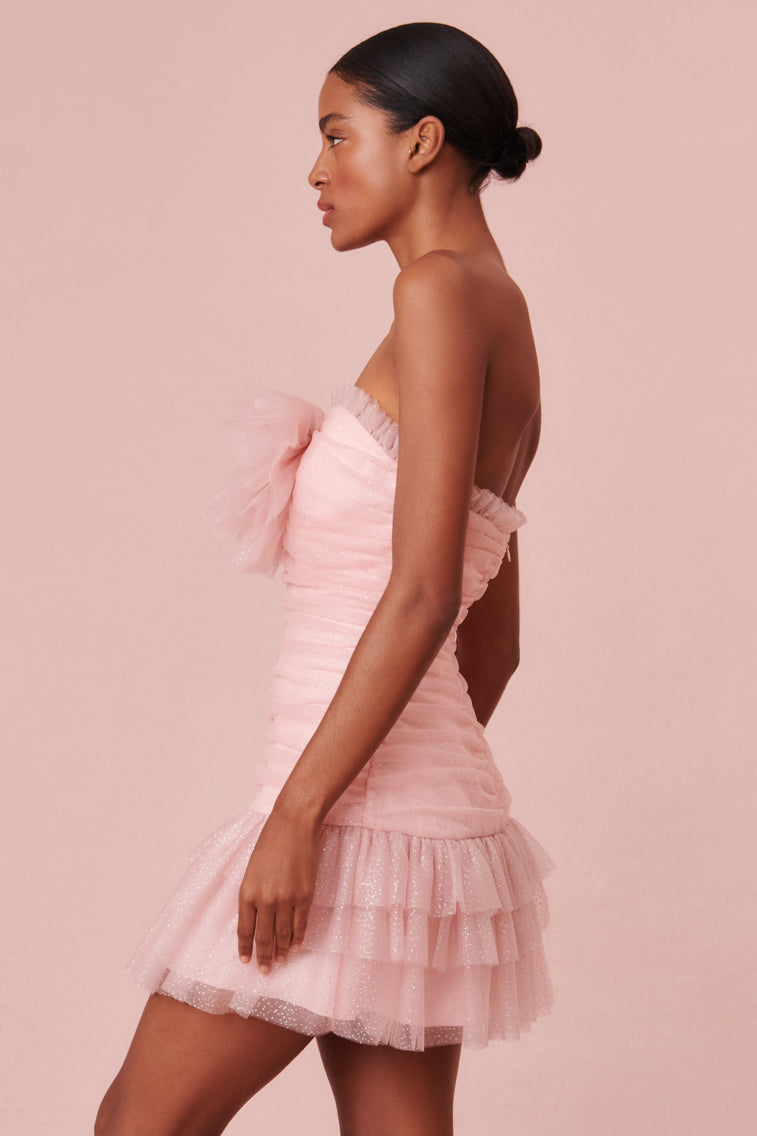  Pink 80’s-inspired party dress that descends to a flirty ruffle tiered mini skirt. 
