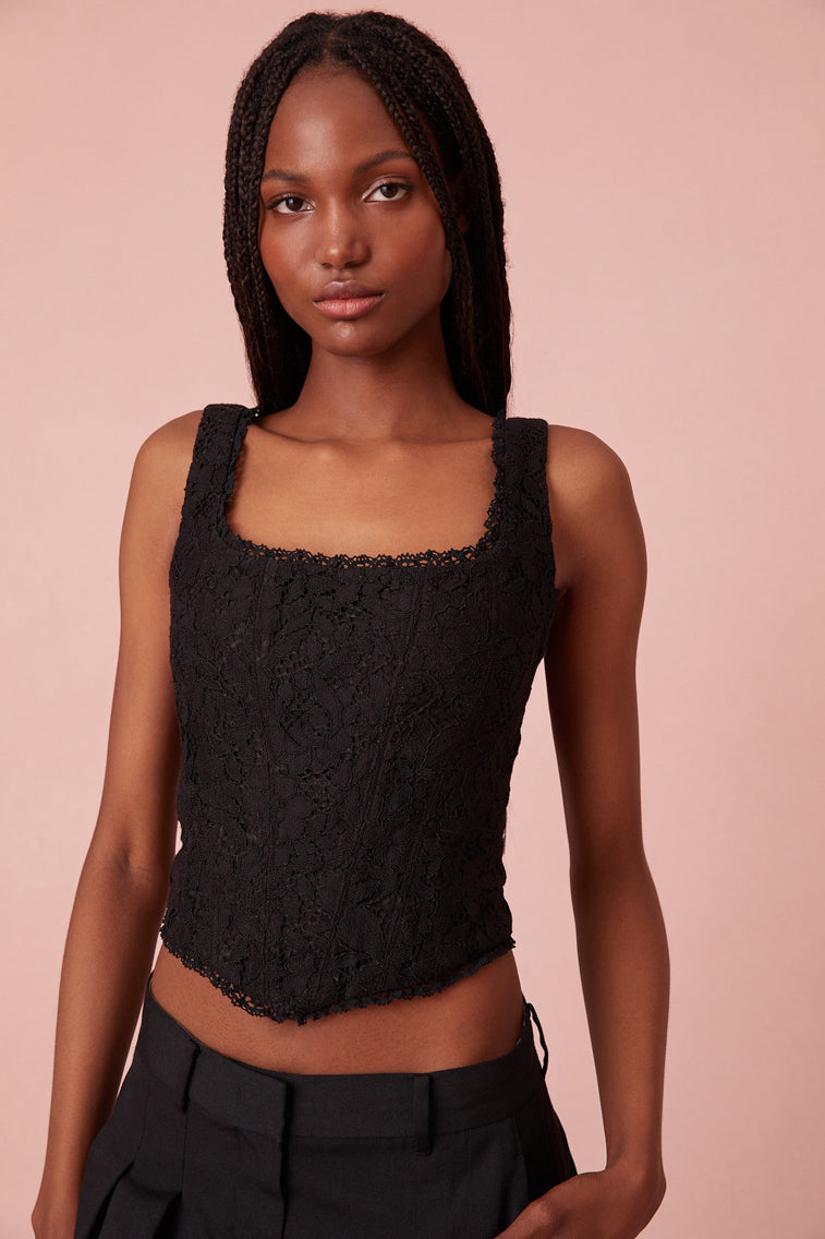 Black bustier top with an open square neck, a V-shaped base and an array of different handmade flowers.