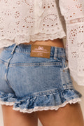 Denim shorts with lace trim and a visible brand label on a neutral background