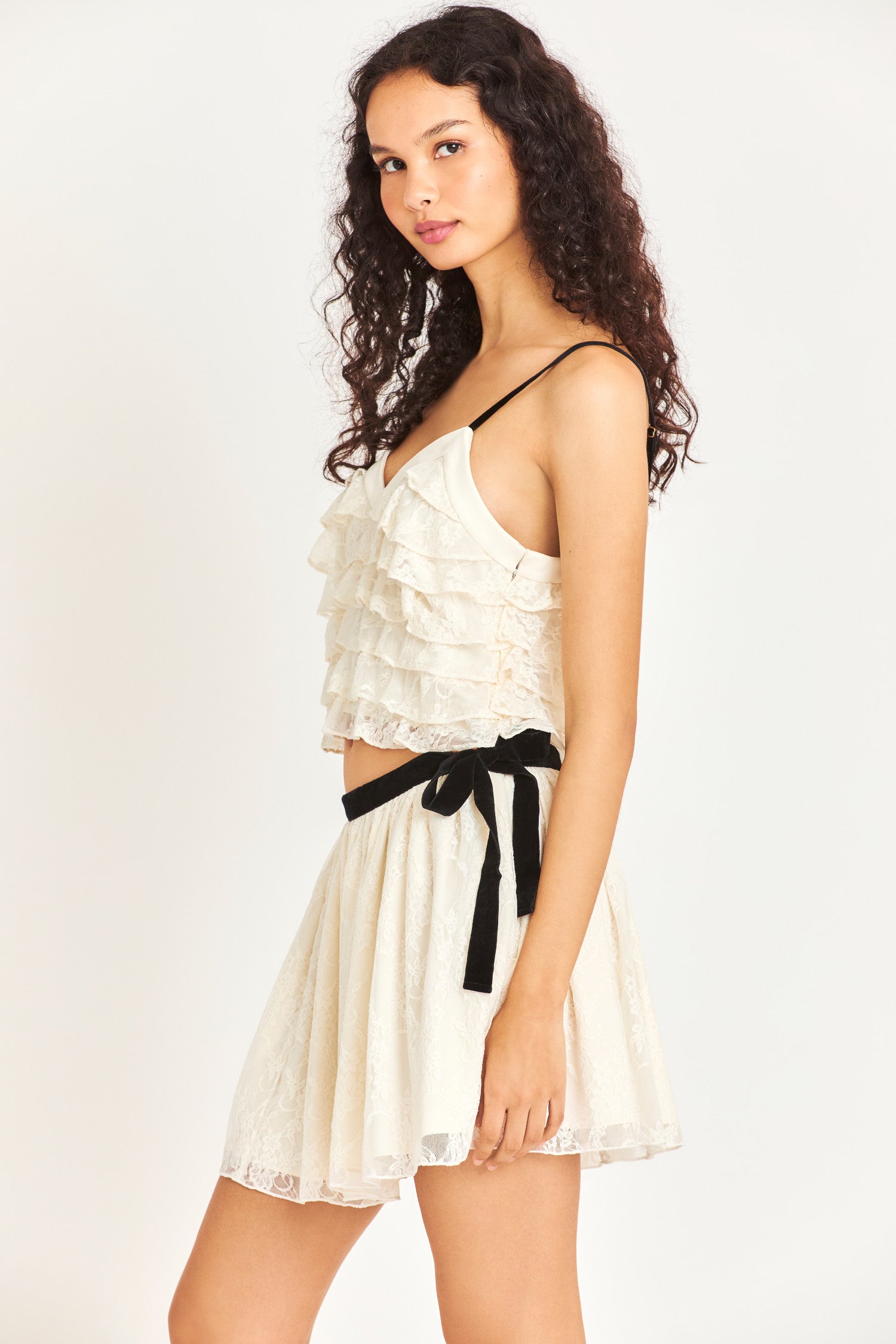 Side image of model wearing white mini skirt with black waistband