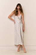 Woman wearing a beige and blue striped dress against a plain background