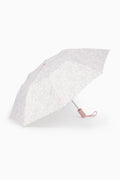 White umbrella with a subtle pink bow pattern on a white background