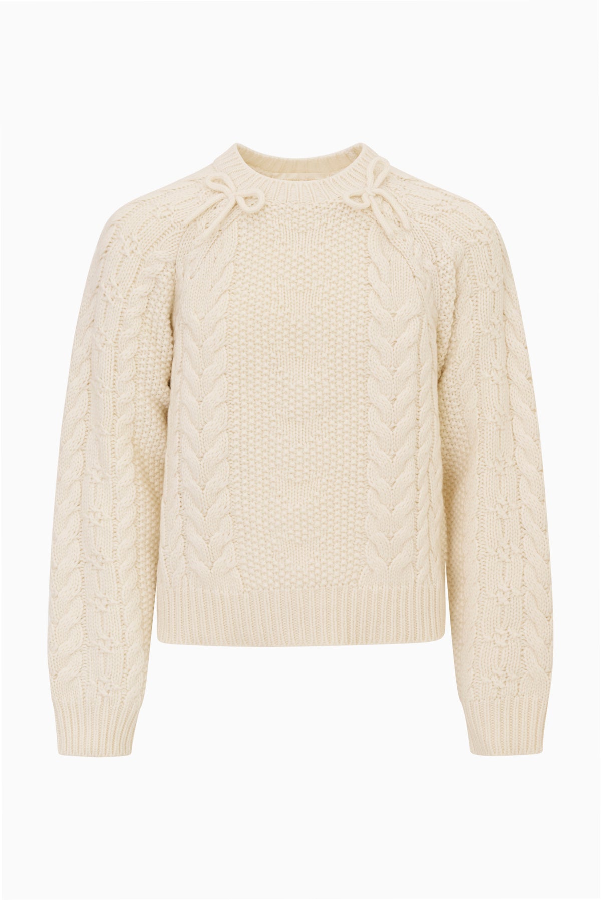 Tween Mavita cable-knit pullover sweater in cream with crew neck, long sleeves, and bow details at the neckline